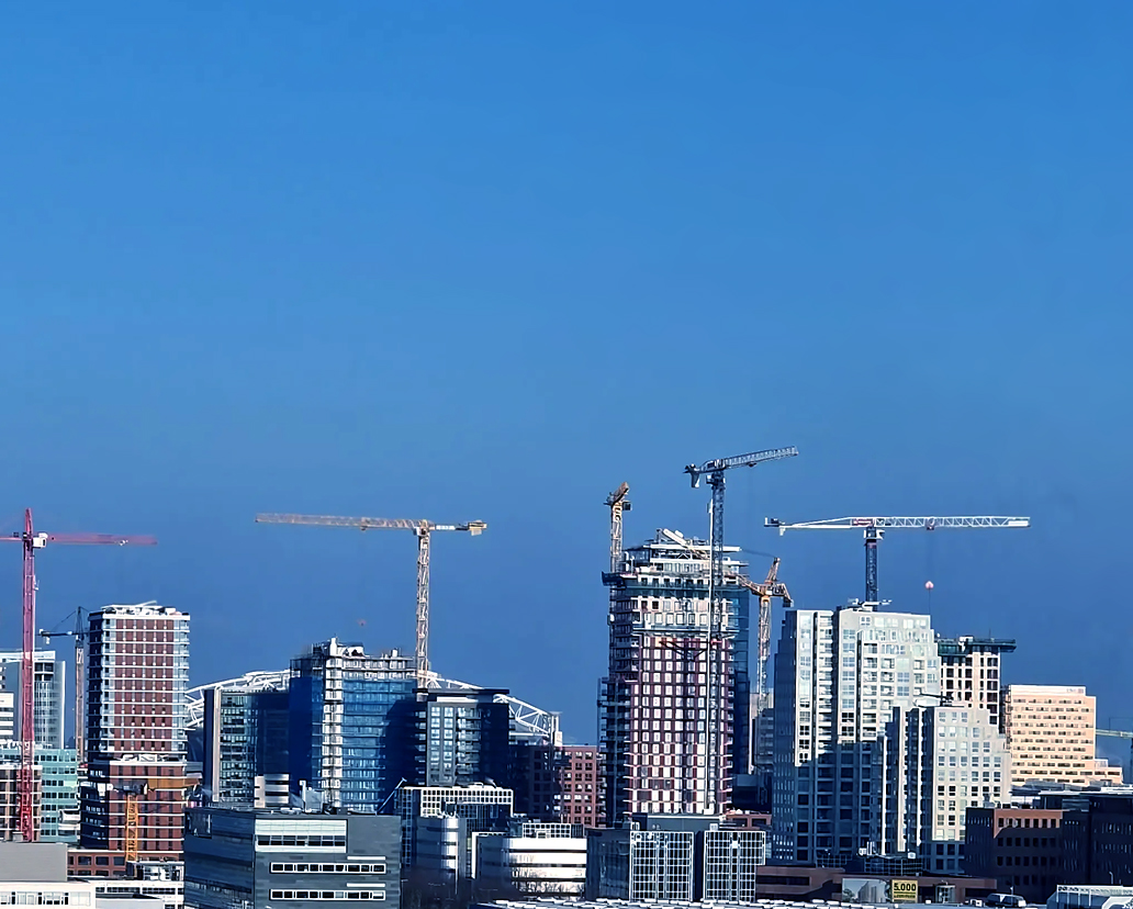 Skyline van een bouwproject met kranen tijdens zonsondergang
